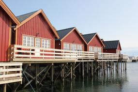 Fire r&oslash;de rorbuer med terrasse over vannet