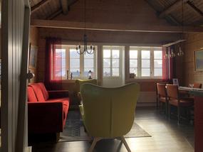 Stue og spisestue med gamle trevegger. En r&oslash;d sofa og to limegule lenestoler. Et spisebord med seks oransje stoler