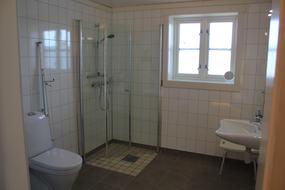 Stort handikapbad men spesiell vask, toalettst&oslash;tte og en og krakk til dusj.