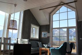 Stue med en sofa, et bord, to lenestoler og et middagsbord med fire stoler.