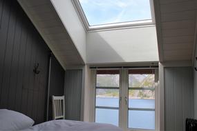 Hovedsoverom med to single senger, takvindu ut mot Reinefjorden. Stol og knagg ved siden av sengen  