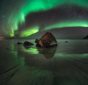 Gr&oslash;nt nordlys over Skagsanden stranda i Flakstad.