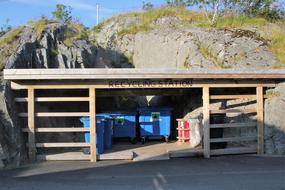 Milj&oslash;stasjon med separate s&oslash;ppelb&oslash;tter for plastikk, papir/kartonger, glass/metall, matavfall, restavfall og panteflasker. 